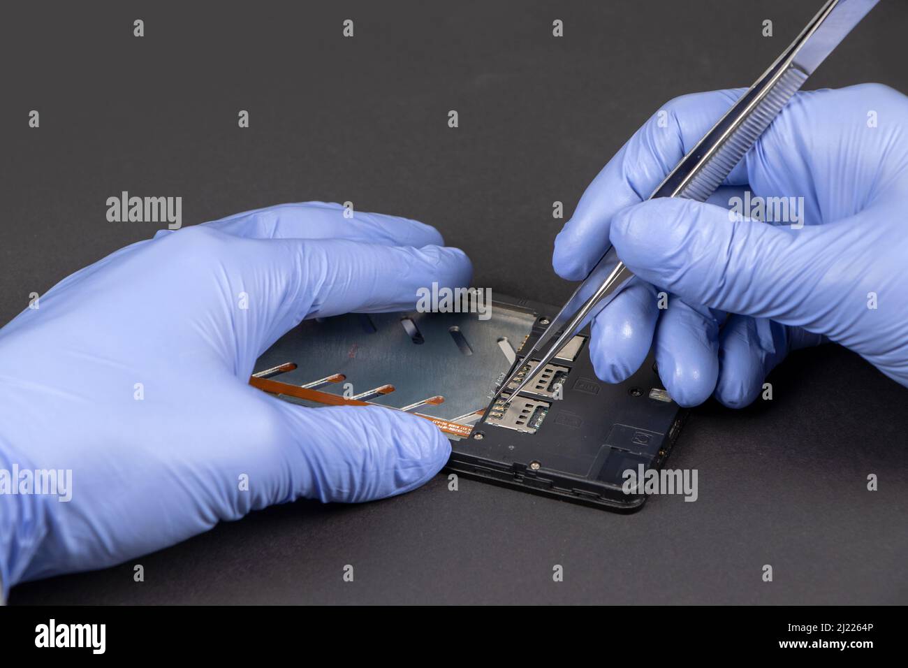 Processus de réparation de téléphone mobile. Mains d'un technicien de maintenance qui répare un téléphone mobile moderne. Banque D'Images