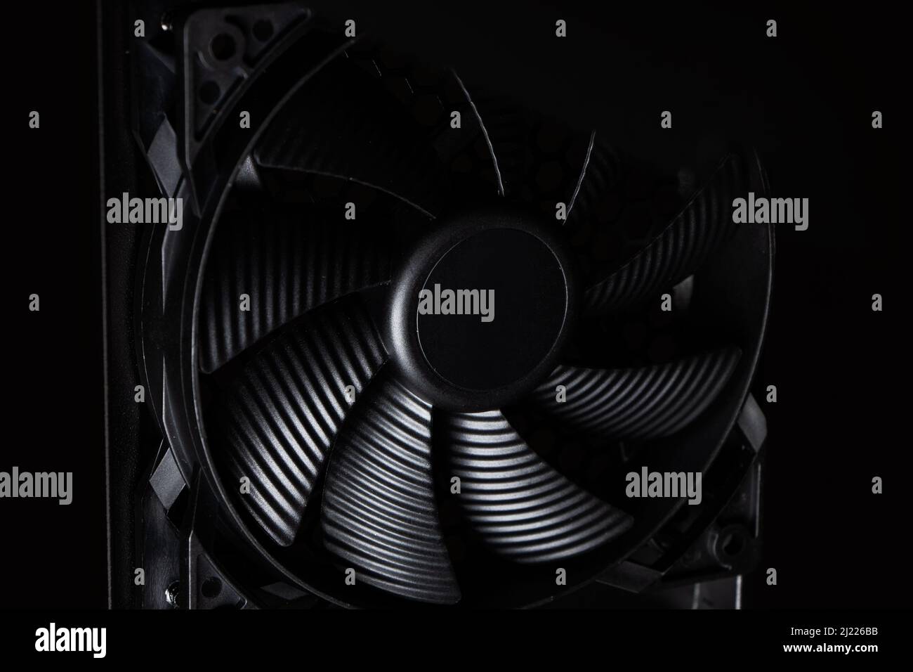 Cachez le ventilateur de l'ordinateur sur un arrière-plan sombre. Banque D'Images