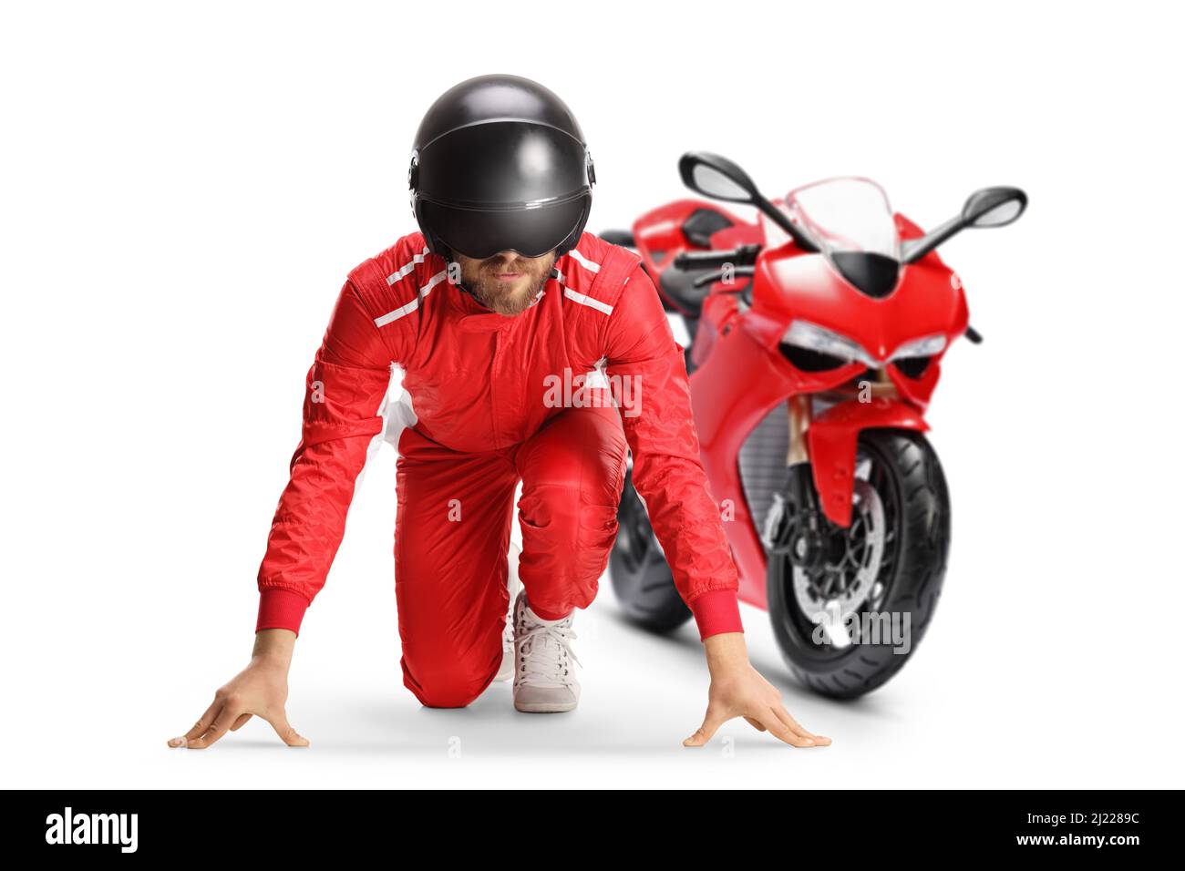 Racer en position de départ pour courir devant une moto rouge isolée sur fond blanc Banque D'Images