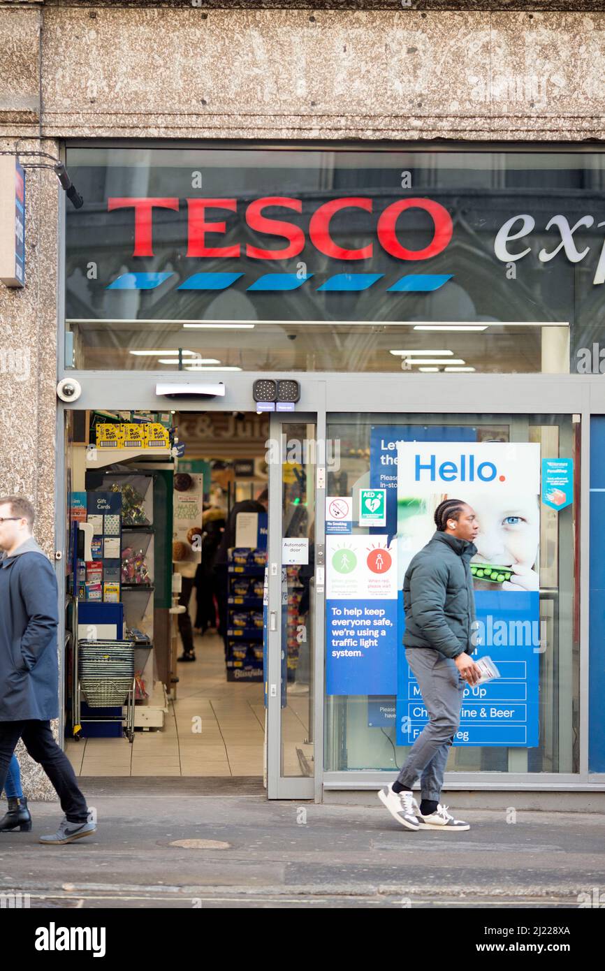 Les gens quittent et entrent dans un magasin Tesco dans le centre de Londres après l'entrée en vigueur des règles du plan B Covid-19. Banque D'Images