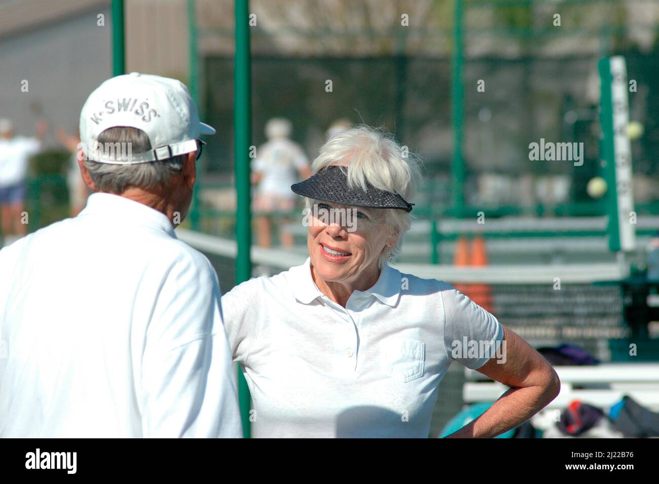 Femme joueur de tennis senior le faisant quotidiennement comme un hobby et pour s'amuser avec les cheveux blancs et la grande forme et le style à 70+ enseignement d'autres aînés Banque D'Images