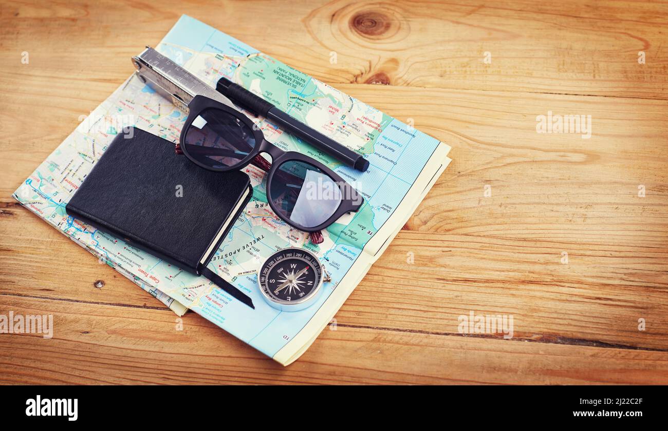 J'ai été partout, mais il est sur ma liste. Photo grand angle de lunettes de soleil, un carnet, un compas et un outil utilitaire sur une carte. Banque D'Images