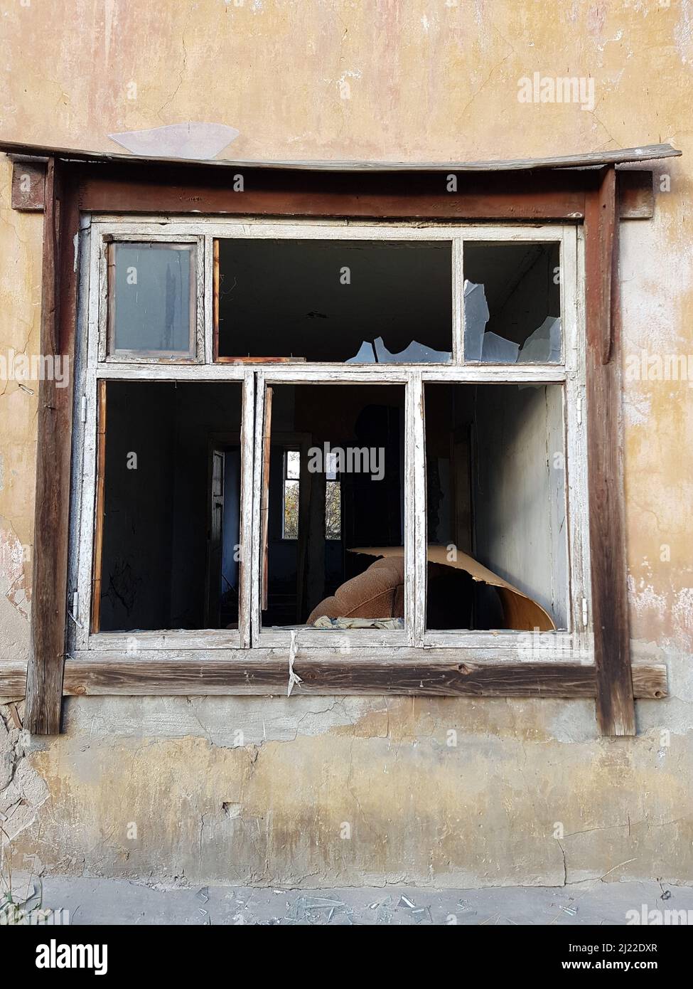 Les fenêtres d'une ancienne maison abandonnée avec du verre brisé. Un bâtiment vide sans portes ni fenêtres. Le concept de démolition ou d'effondrement d'un bâtiment Banque D'Images