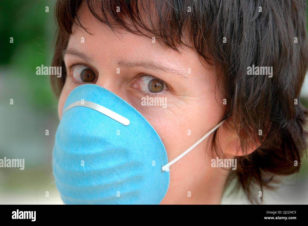 Femme portant un masque stérile sanitaire pour des raisons d'hygiène sur le visage, la bouche et le nez au moment de la maladie et des germes et des insectes et de la maladie - avant Covid Banque D'Images