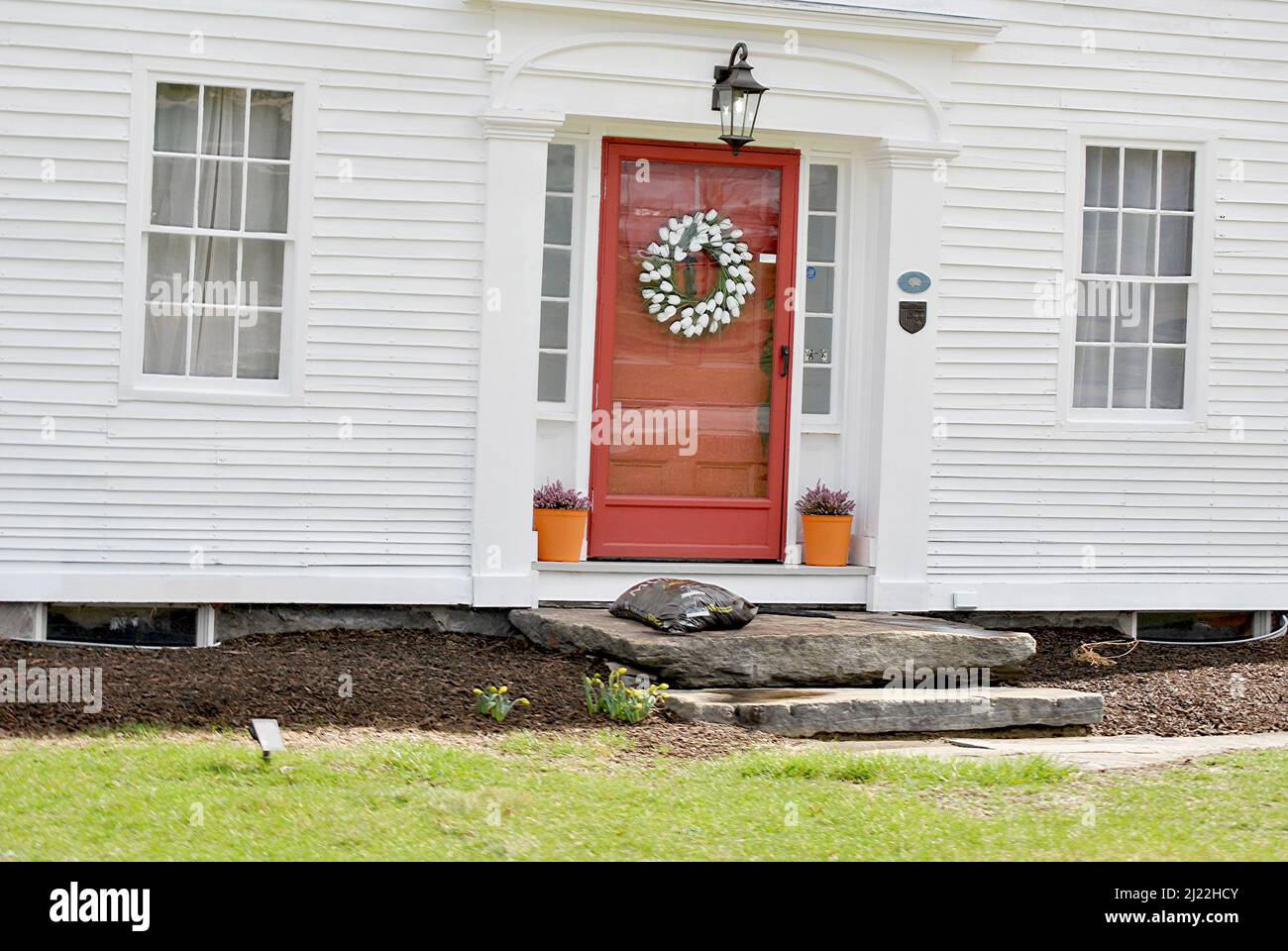 Un vieux bâtiment blanc avec une couronne de printemps Banque D'Images