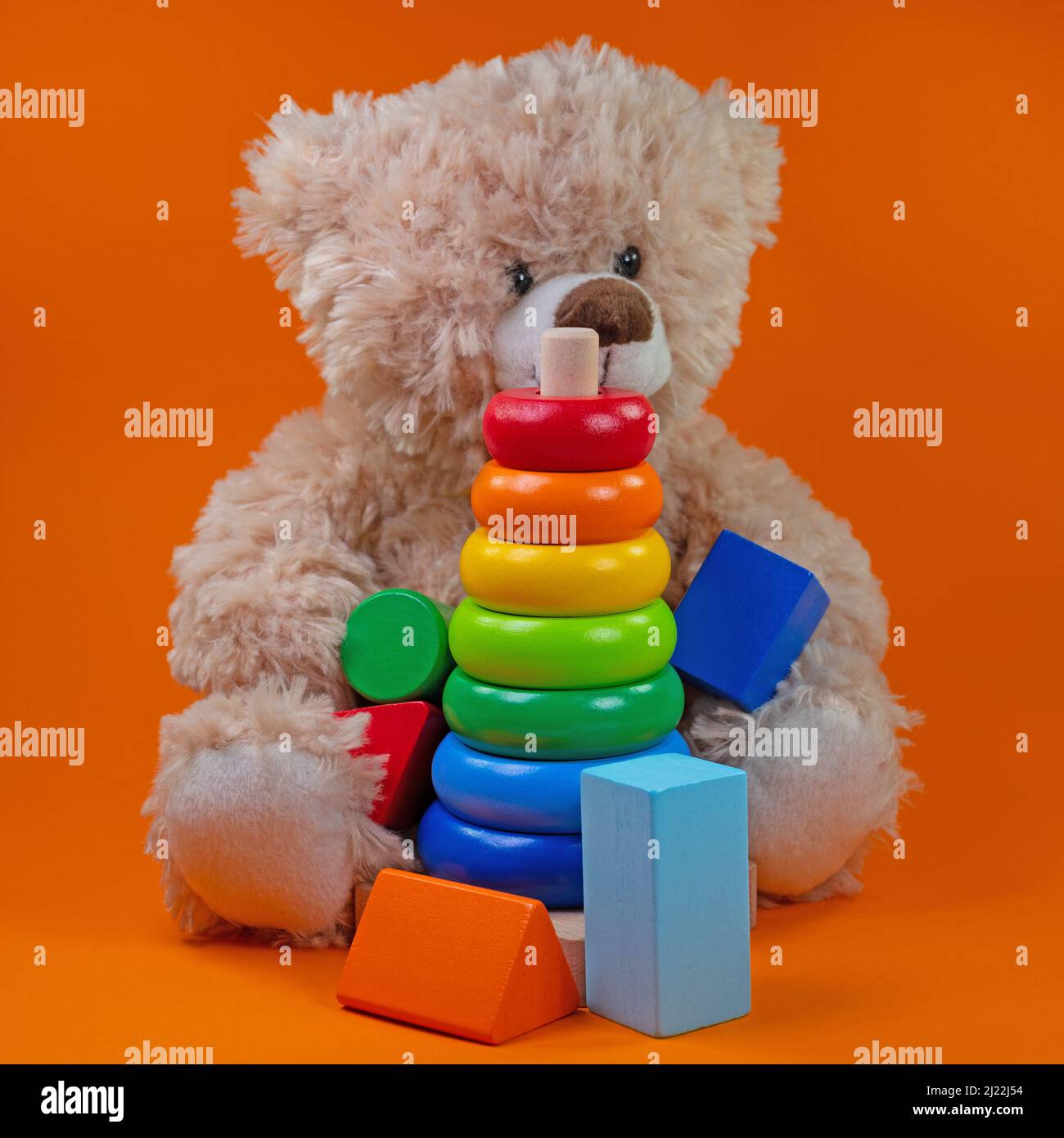 Jouets en bois et ours en peluche sur fond orange Banque D'Images