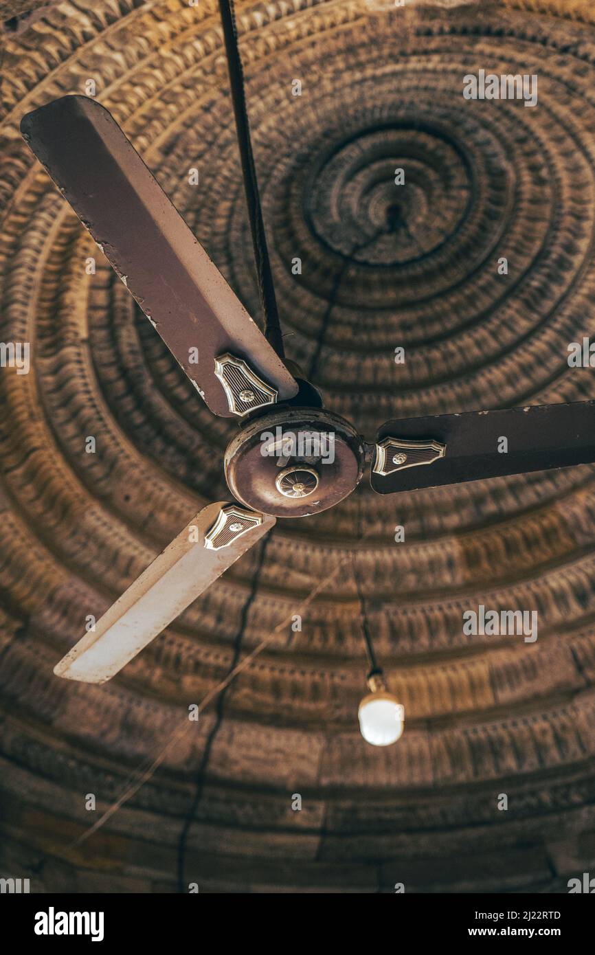 Un gros plan vertical d'un vieux lustre avec '10' écrit dessus, accroché à un beau plafond Banque D'Images