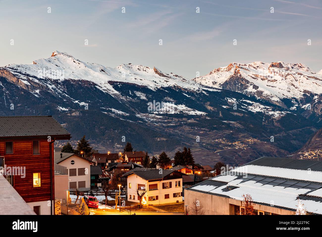 Coucher de soleil, nuit tombée dans les alpes suisses avec des montagnes en arrière-plan et la lumière des maisons, beaucoup de neige, Nendaz, Suisse Banque D'Images