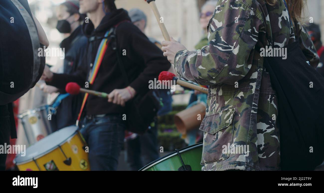 Londres, Royaume-Uni - 03 19 2022: Une femme extinction rébellion climat manifestant jouer à la percussion battant sur un tambour, à Portland place. Banque D'Images
