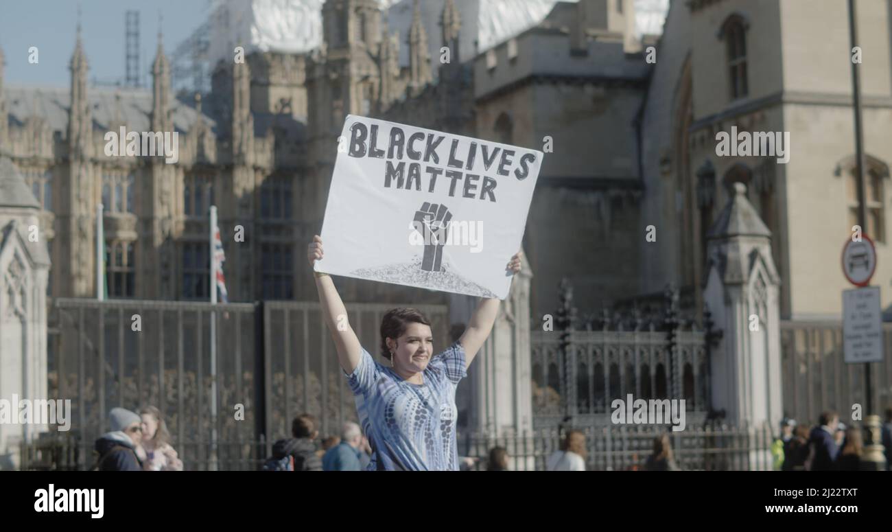 Londres, Royaume-Uni - 03 19 2022: Une femme portant un panneau sur la place du Parlement, «Black Lives Matter», pour l'année «la marche contre le racisme». Banque D'Images