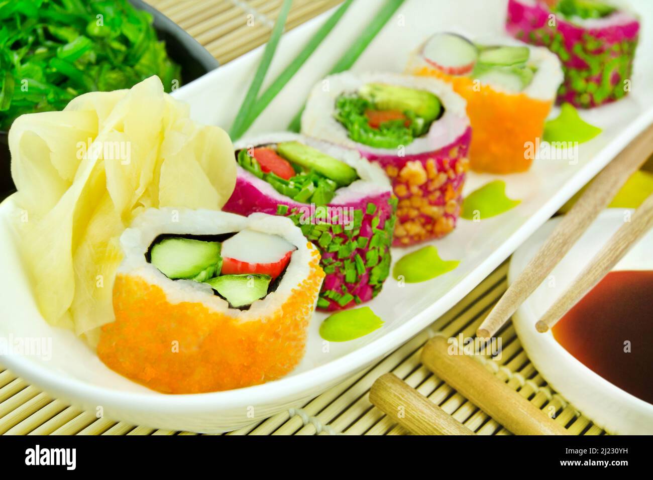 Divers rouleaux de sushi Masago Classic Roll et Veggie California Roll avec sauce soja, gingembre, wasabi et salade wakame Banque D'Images