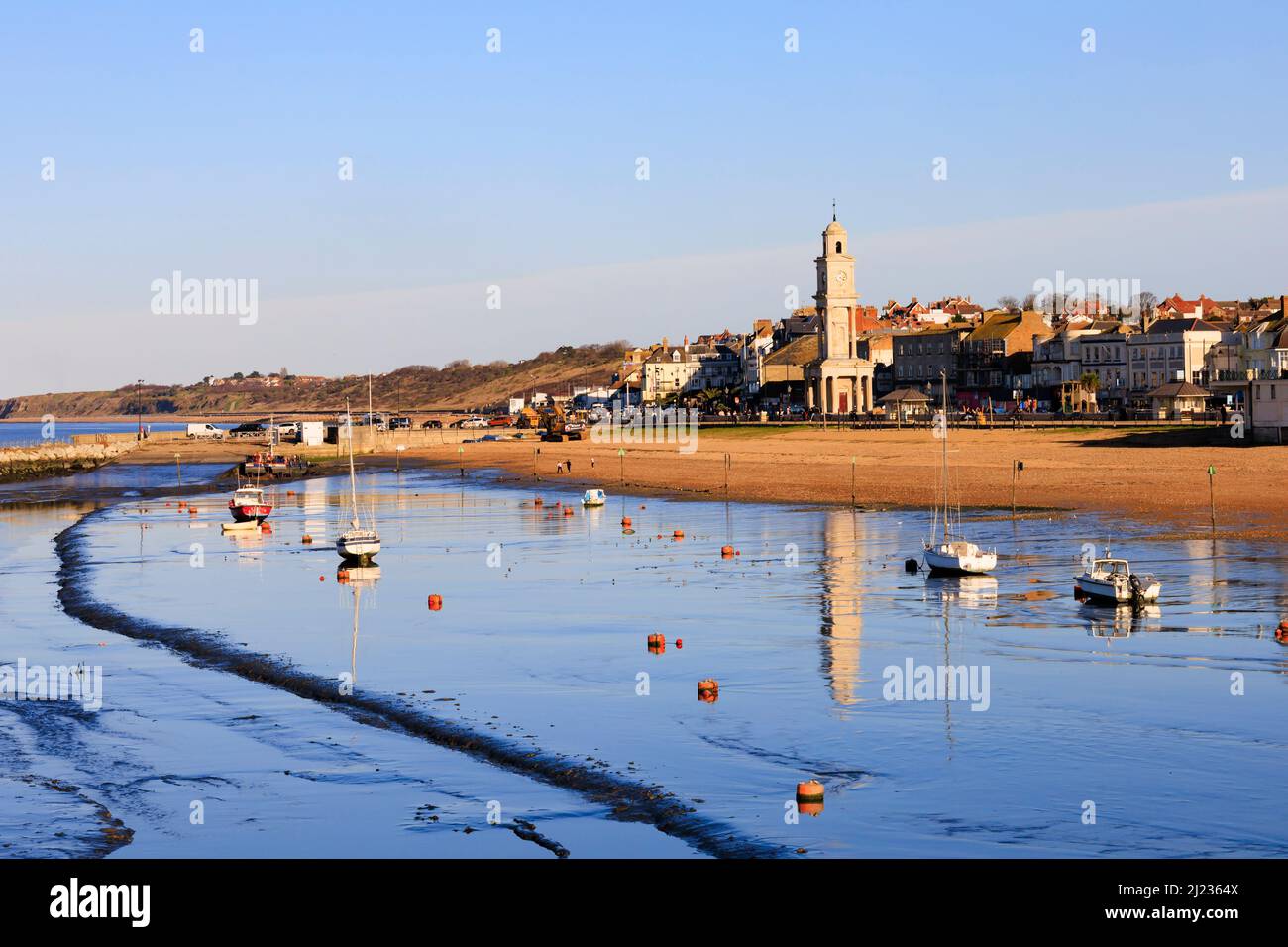 Front de mer avec marée. La tour de l'horloge se reflète dans l'eau de mer.Herne Bay, Kent, Angleterre Banque D'Images