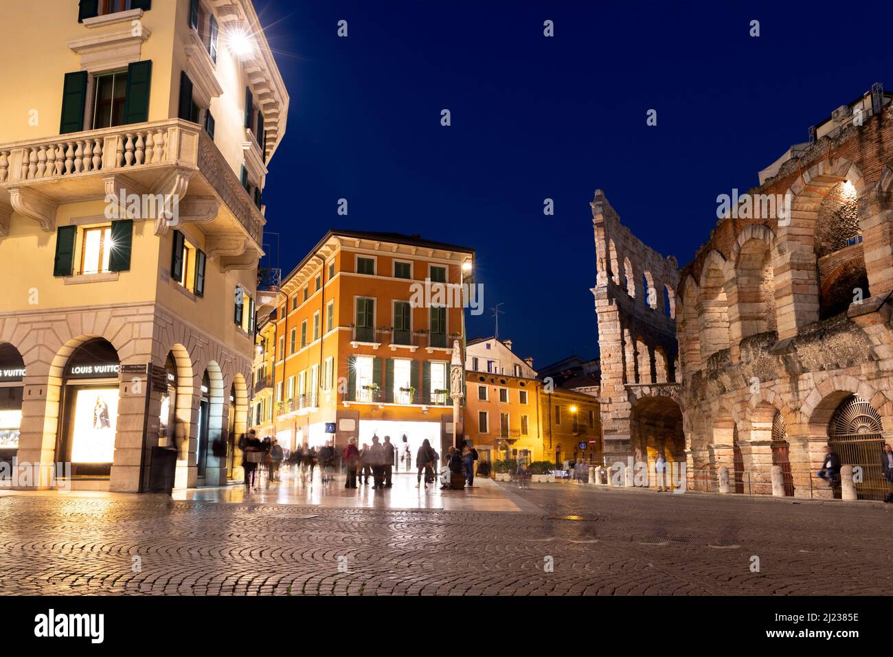 Italie, Vérone, l'Arena di Verona, un amphithéâtre romain au crépuscule avec des gens dans la vieille ville historique au crépuscule. Banque D'Images