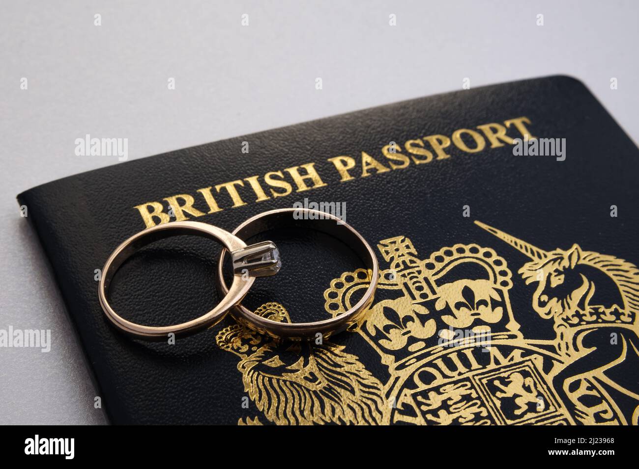 Anneaux dorés sur un nouveau passeport britannique bleu foncé. Concept de visa de fiance britannique ou de visa de conjoint. Stafford, Royaume-Uni, 29 mars 2022. Banque D'Images