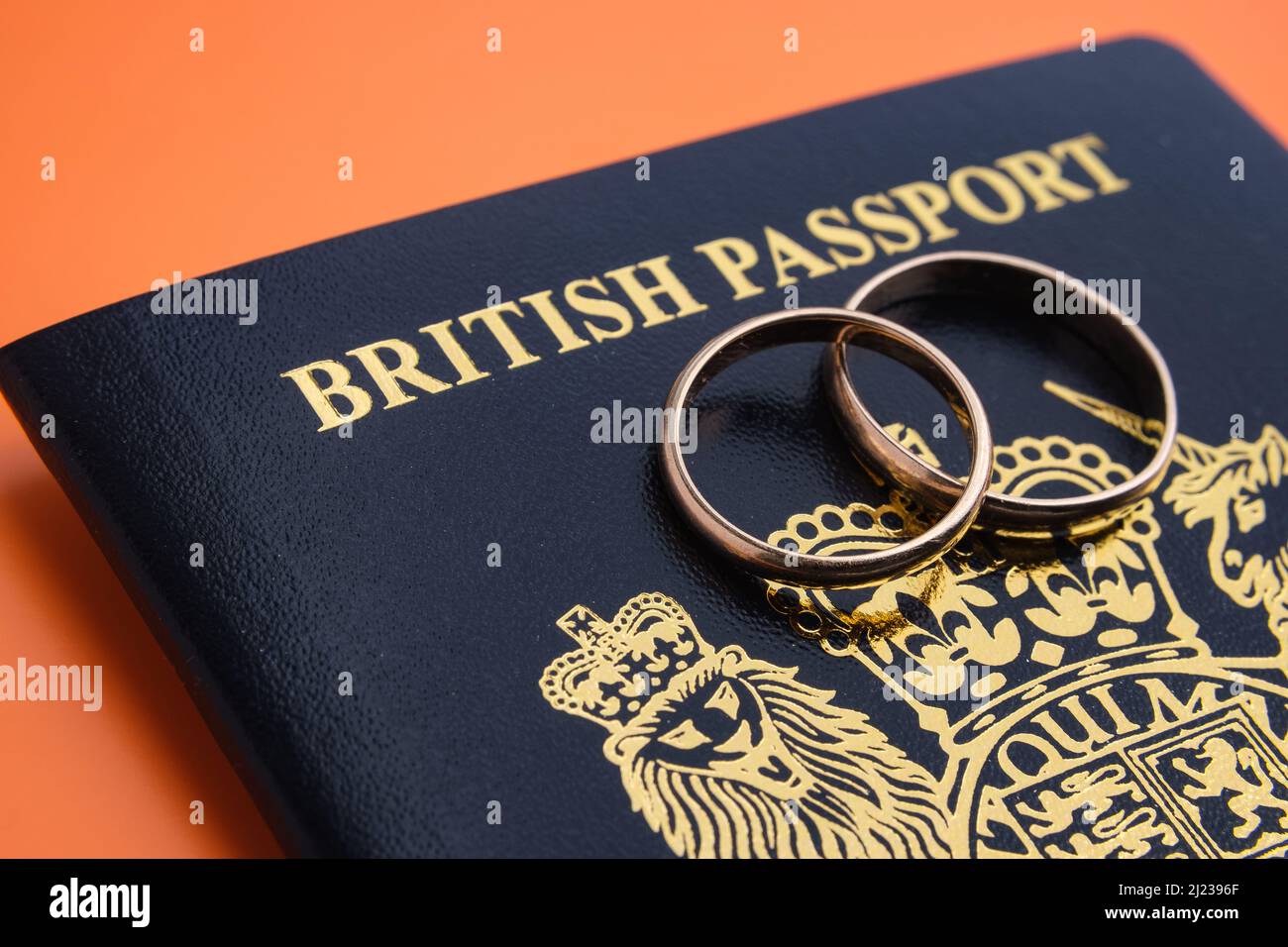 Anneaux dorés sur un nouveau passeport britannique bleu foncé. Concept de visa de fiance britannique ou de visa de conjoint. Stafford, Royaume-Uni, 29 mars 2022. Banque D'Images