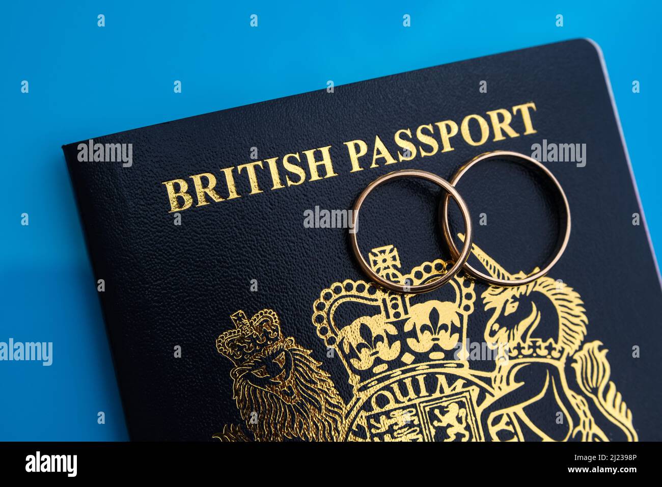 Anneaux dorés sur un nouveau passeport britannique bleu foncé. Concept de visa de fiance britannique ou de visa de conjoint. Stafford, Royaume-Uni, 29 mars 2022. Banque D'Images