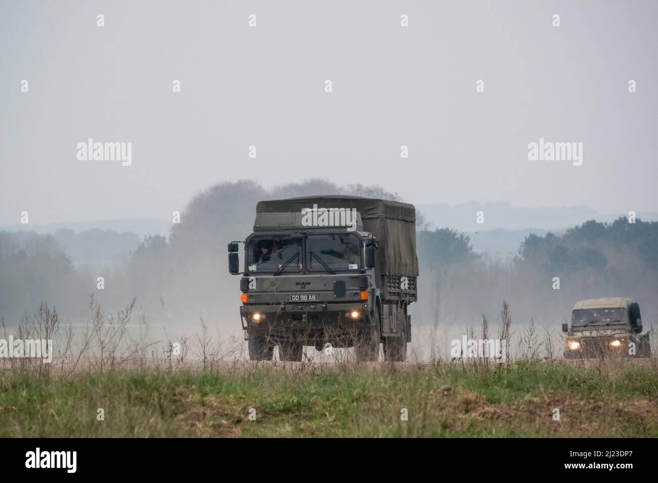 Un petit convoi de véhicules utilitaires intermédiaires Land Rover Defender Wolf de l'armée britannique et un CAMION logistique 4x4 SV D'HOMME lors d'un exercice militaire Banque D'Images