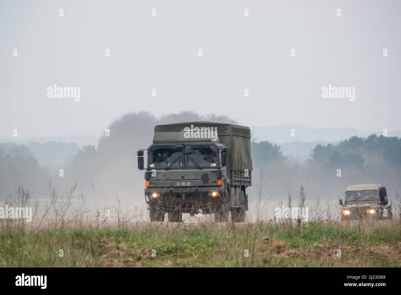 Un petit convoi de véhicules utilitaires intermédiaires Land Rover Defender Wolf de l'armée britannique et un CAMION logistique 4x4 SV D'HOMME lors d'un exercice militaire Banque D'Images