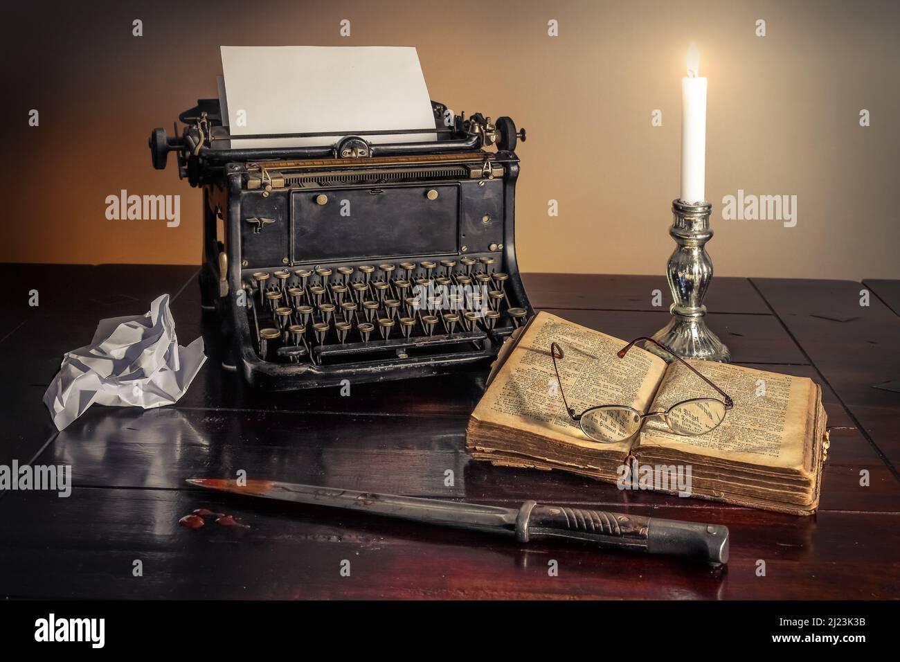 Une machine à écrire vintage sur une table à côté d'un couteau de meurtre et un livre.Un concept d'histoire de détective. Banque D'Images