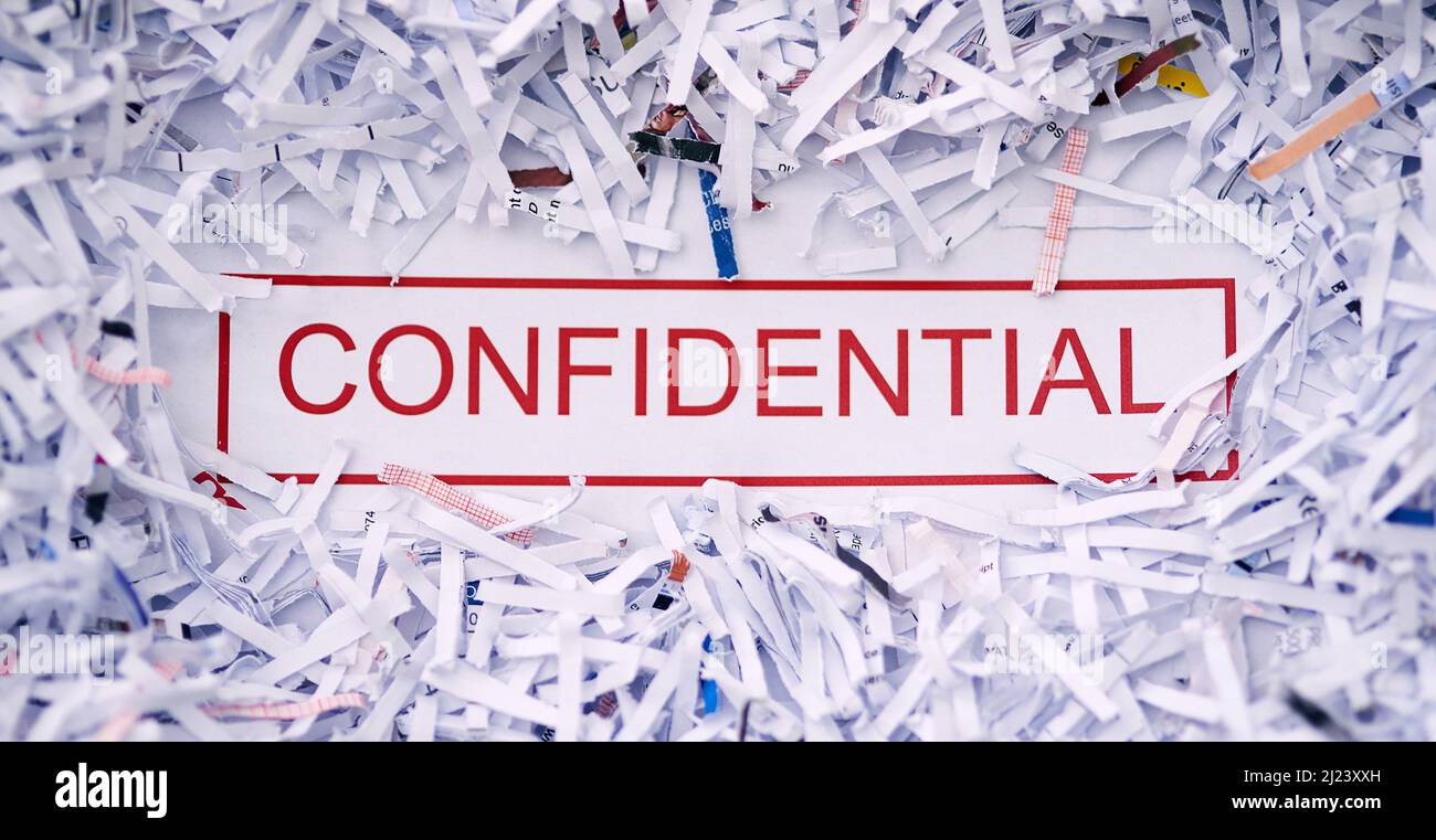 Gardez-le confidentiel. Studio photo du mot CONFIDENTIEL entouré de papier déchiqueté. Banque D'Images