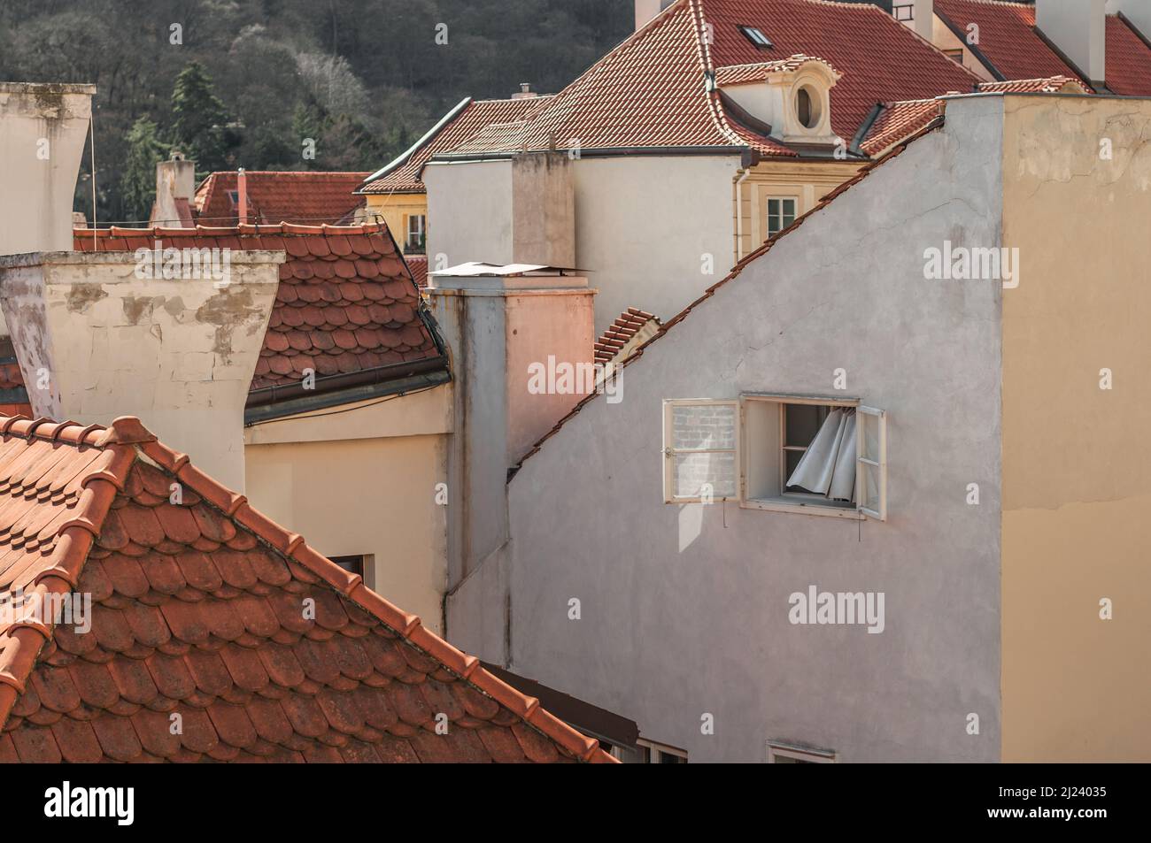 Vue sur une fenêtre ouverte avec un rideau dans la vieille ville de Prague. Banque D'Images