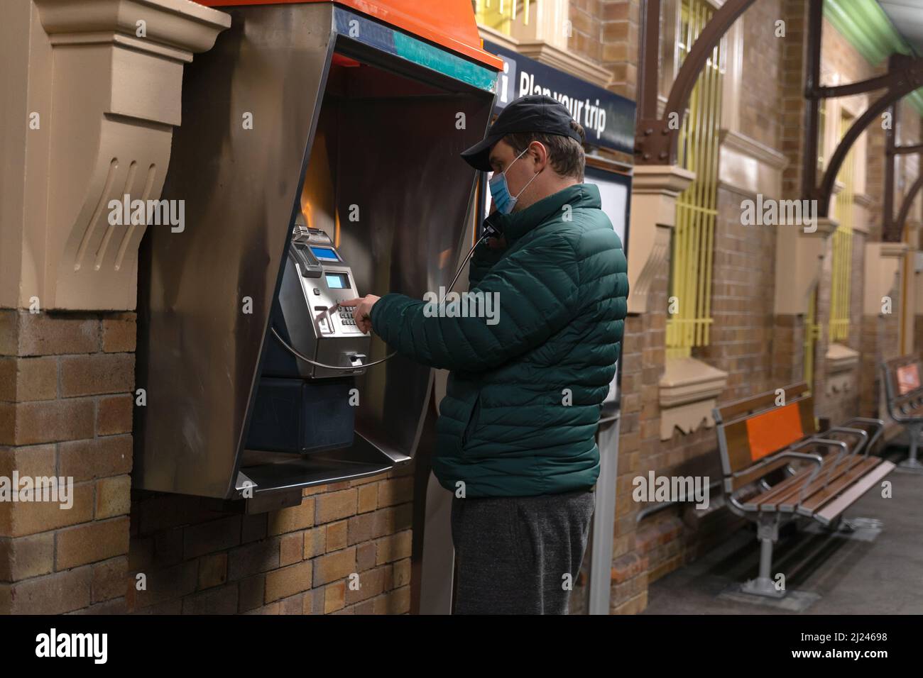 Un homme effectuant un appel sur un téléphone payant Banque D'Images
