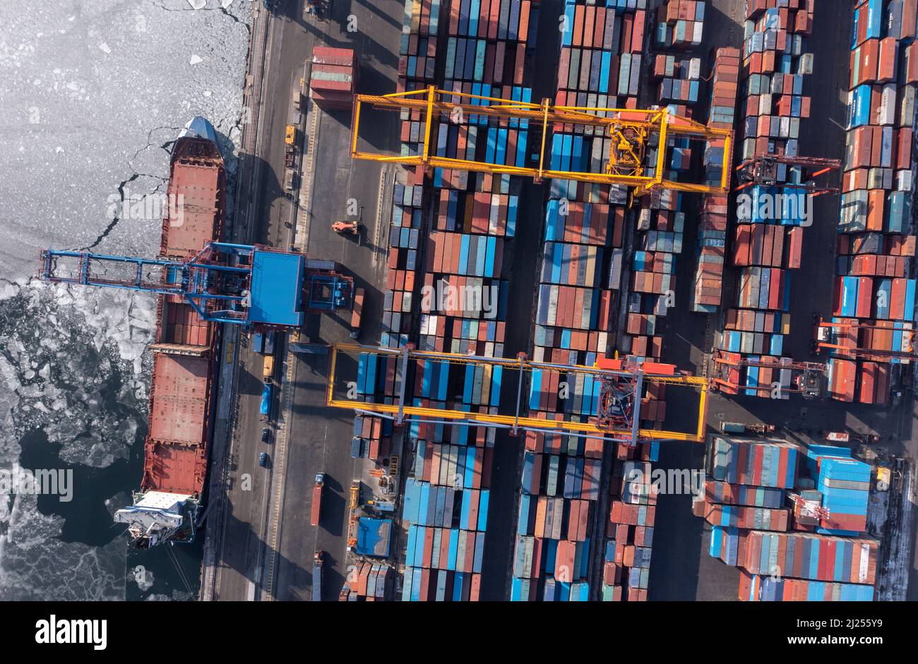 Vladivostok, Russie - 27 janvier 2022 : Vue de dessus du terminal des conteneurs du port maritime. En hiver, un bateau à conteneurs est en train de charger au quai. Banque D'Images