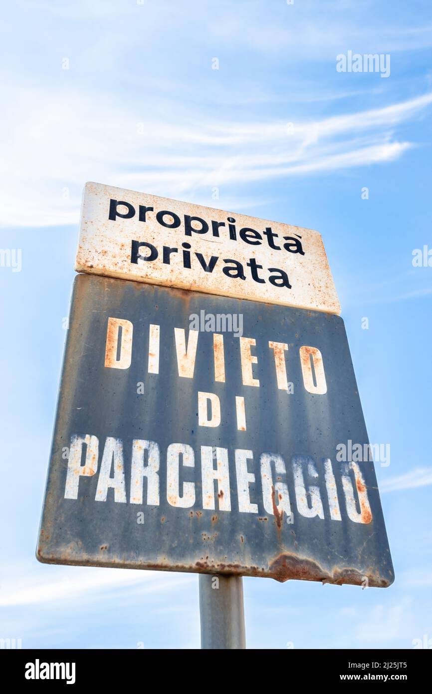 Vieux panneau rouillé pour une place de stationnement privée indiquant que l'étiquette est interdite (traduit de la langue italienne). Banque D'Images