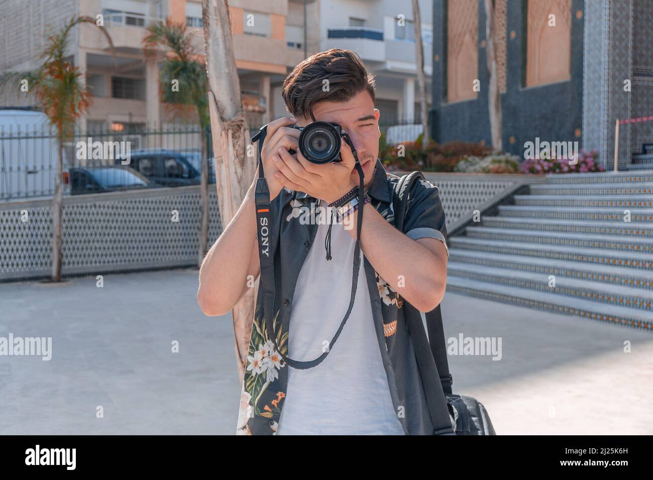 Portrait d'un photographe attrayant prenant des photos à l'aide de son Sony Alpha Banque D'Images