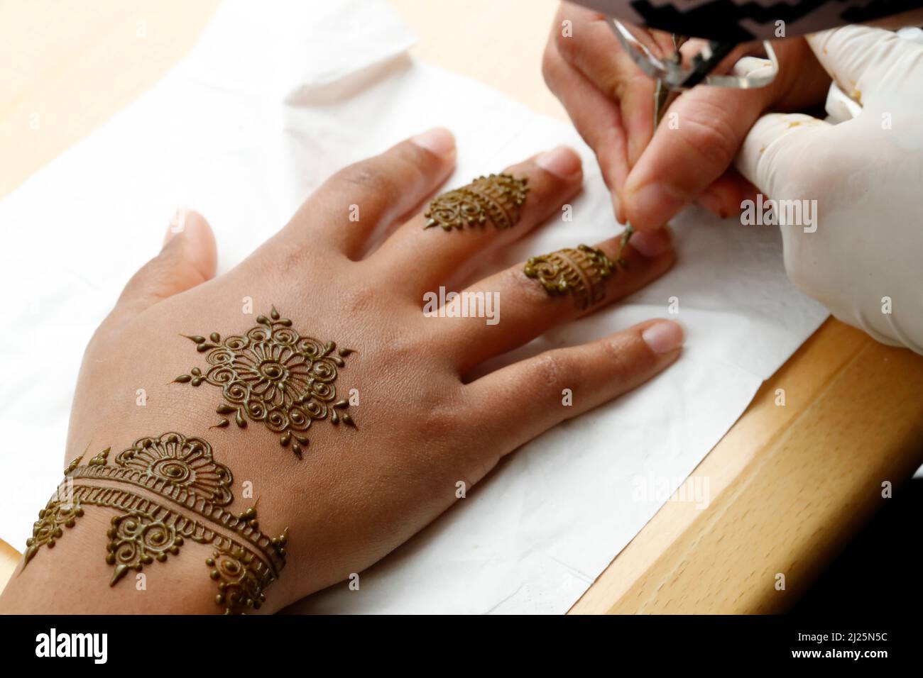 Artiste peintre traditionnel arabe henné tatouage sur la main de femme. Banque D'Images