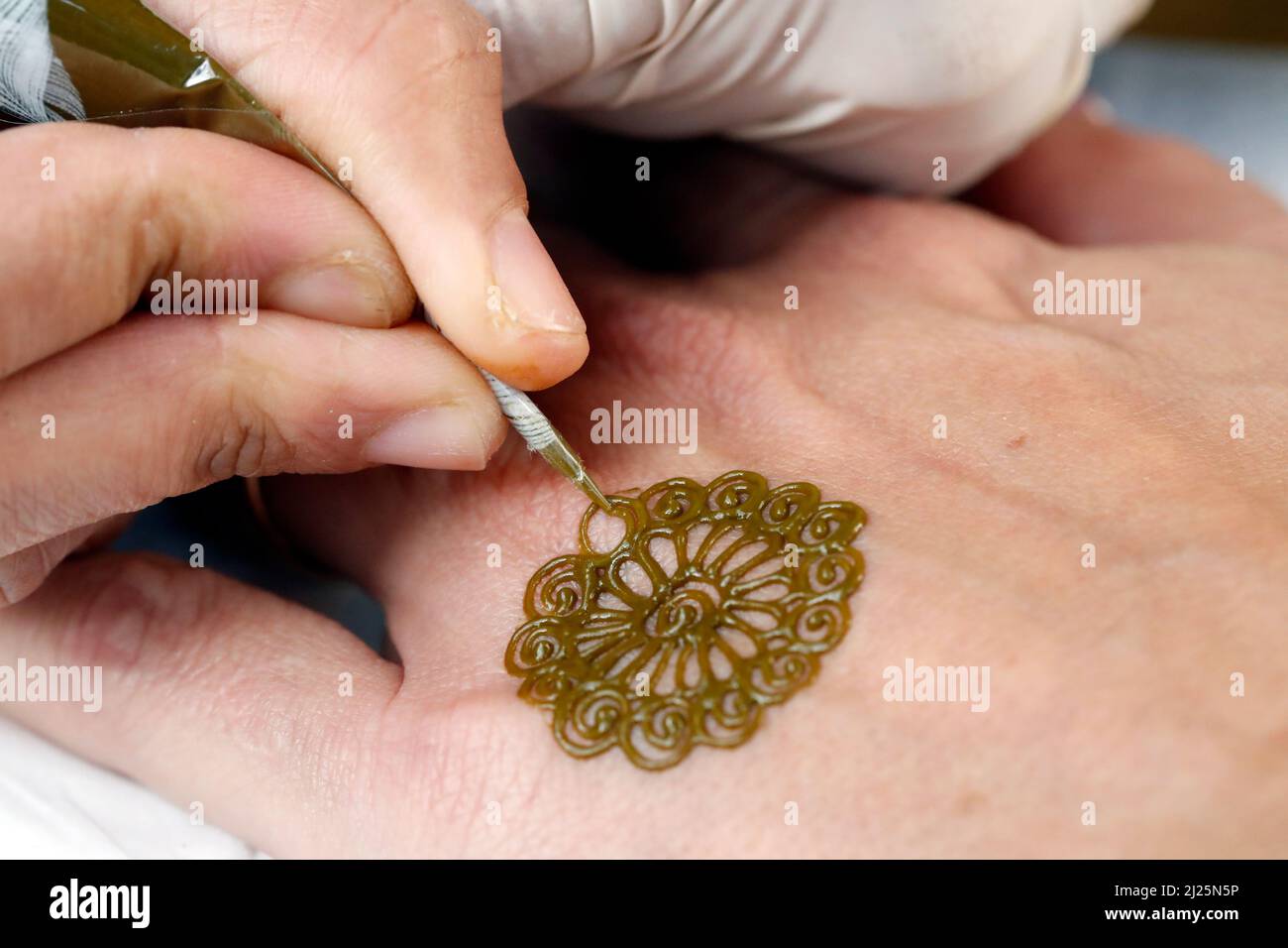 Artiste peintre traditionnel arabe henné tatouage sur la main de femme. Banque D'Images