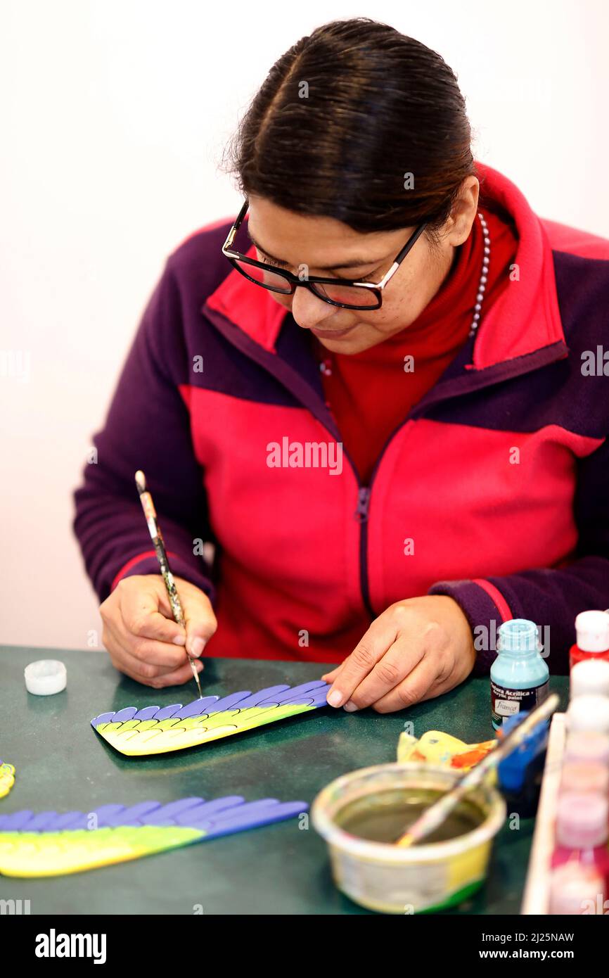 Femme peint des jouets en bois à Cuenca, Equateur Banque D'Images