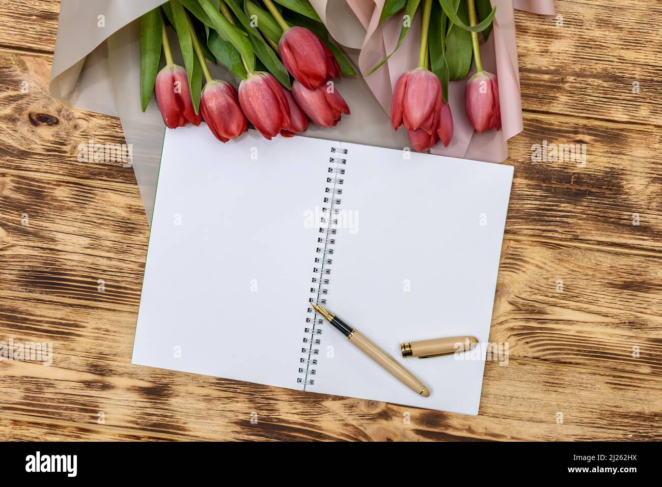 Bloc-notes vierge avec tulipes sur table en bois Banque D'Images