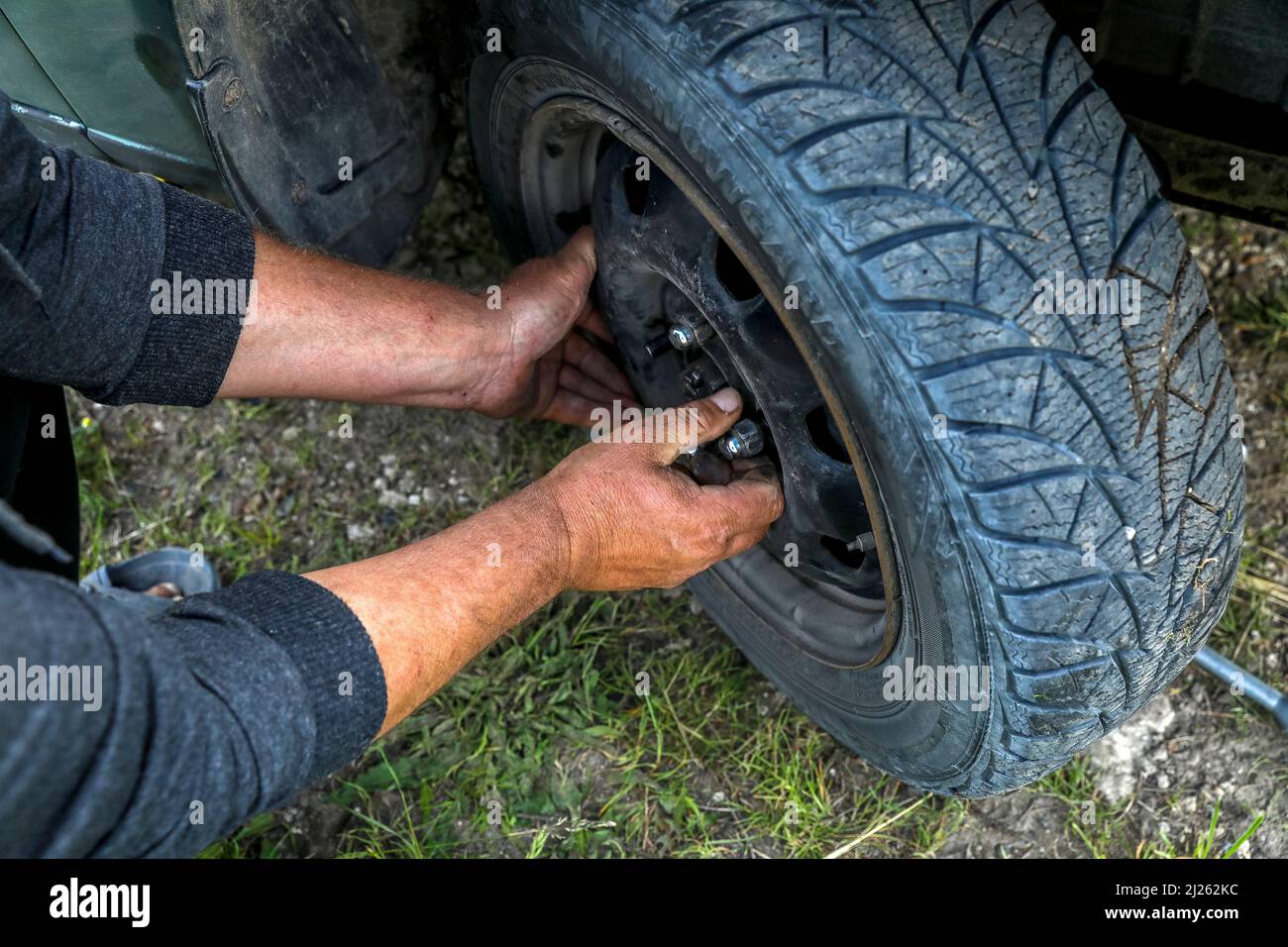 Homme changeant un pneu après une panne dans un village près de Soroca, Moldavie Banque D'Images