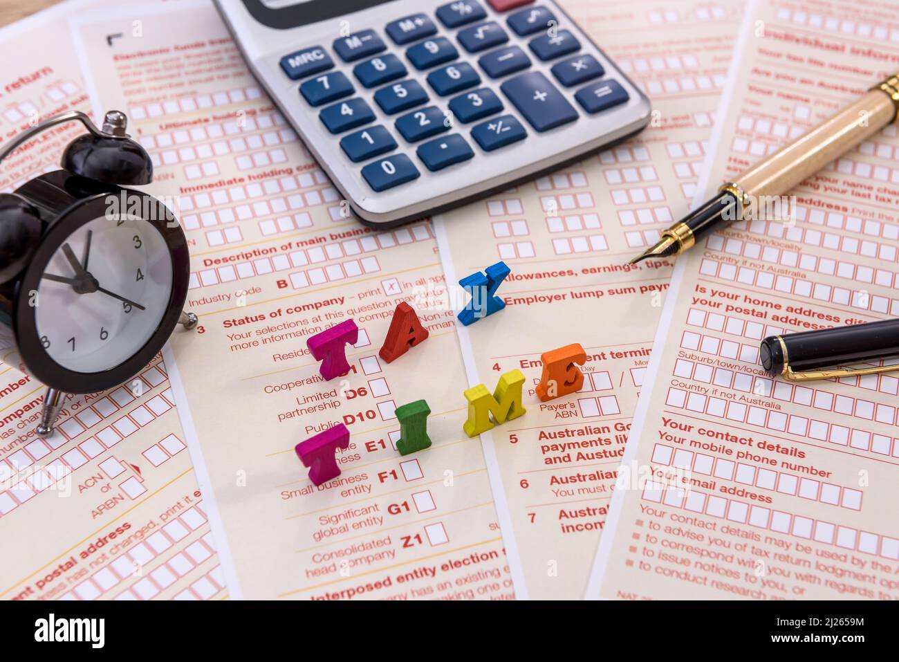 Société fiscale. Texte « heure d'imposition » sur la déclaration australienne avec horloge et calculatrice Banque D'Images