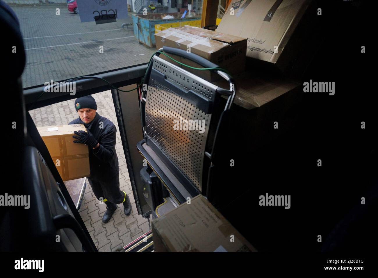 Une garde charge les fournitures d'aide dans un bus appartenant au volontaire britannique Cliff Wilson qui les transportera de Przemysl en Pologne à l'Ukraine et, à son retour, ramasse les femmes et les enfants ukrainiens et les ramasse à la frontière en Pologne. Date de la photo: Mercredi 30 mars 2022. Banque D'Images