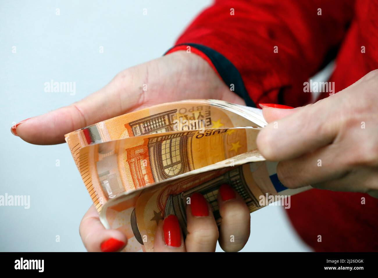 Une femme tient des billets en monnaie euro. Paiement et argent comptant. Argent illégal et cupidité concept. Banque D'Images