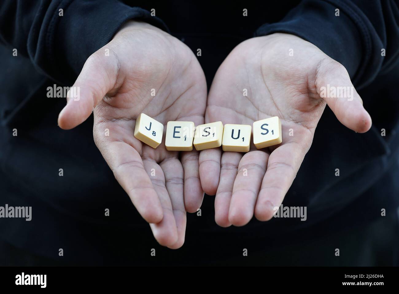 Garçon montrant des lettres épelant Jésus. Eure, France Banque D'Images