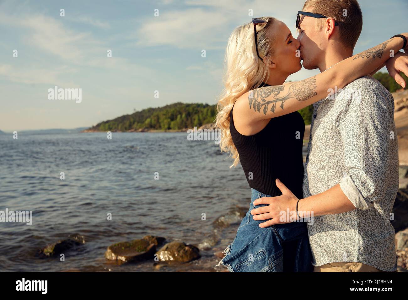 Jeune femme blonde Lissage Boyfriend à la plage Banque D'Images