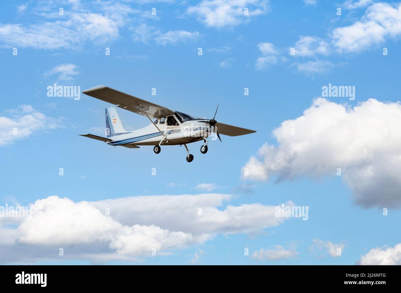 Un seul moteur avion ultraléger volant dans le ciel bleu avec des nuages blancs Banque D'Images
