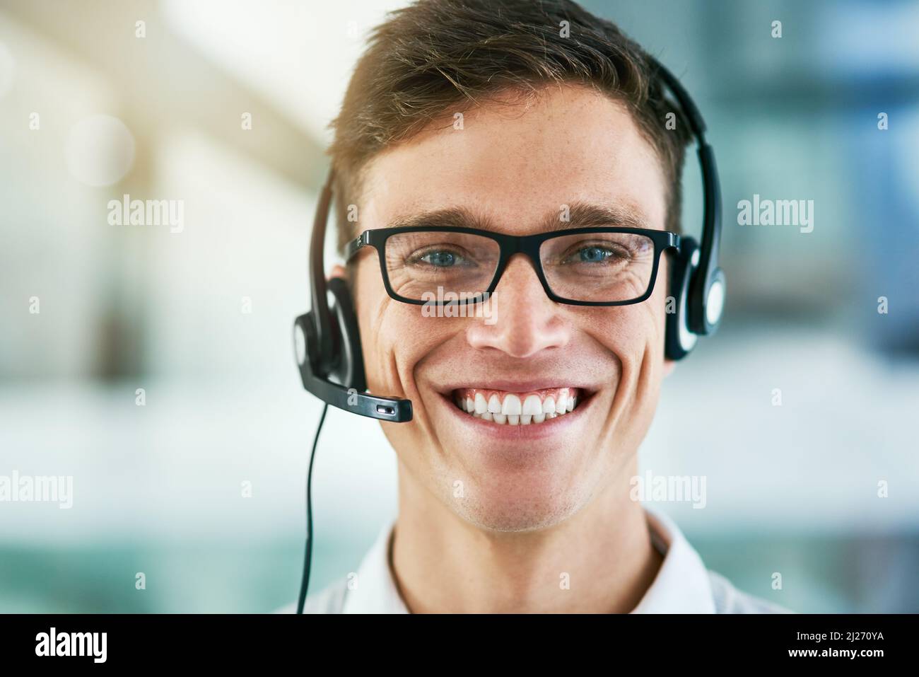 Appelez-nous dès aujourd'hui et bénéficiez d'un service de qualité. Portrait d'un jeune agent de centre d'appels travaillant dans un bureau. Banque D'Images