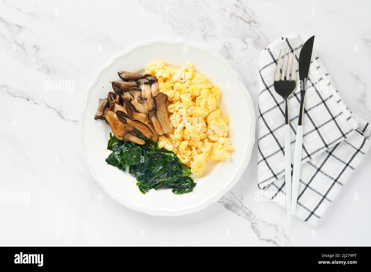 Omelette. Omelette ou frittata aux champignons et au fromage d'huîtres d'épinards sur fond de marbre blanc. Idée petit déjeuner. Vue de dessus avec espace de copie. Banque D'Images