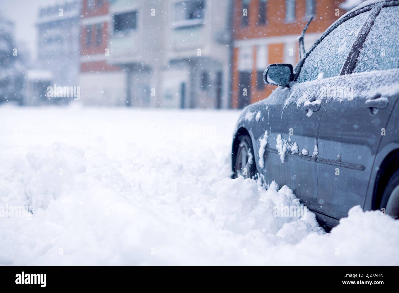 Froid neigeux de l'hiver. Tempête de neige dans la voiture après l'homme. enlever la neige à partir de la voiture. Banque D'Images