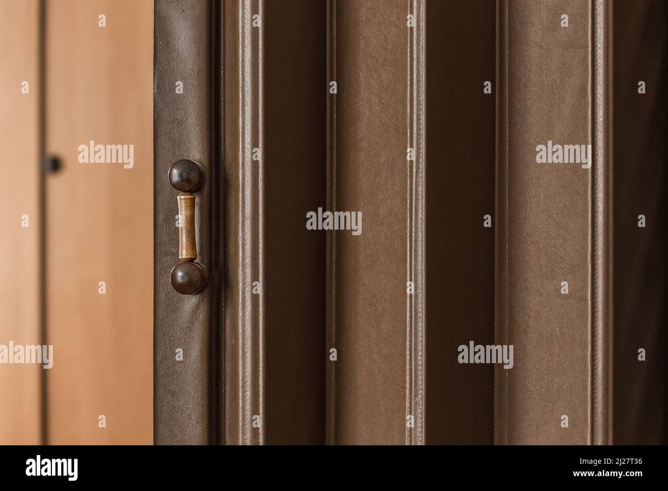 Ancienne porte coulissante antique avec poignée en bois et volets arrière-plan de style rétro rétro à motif brun. Banque D'Images