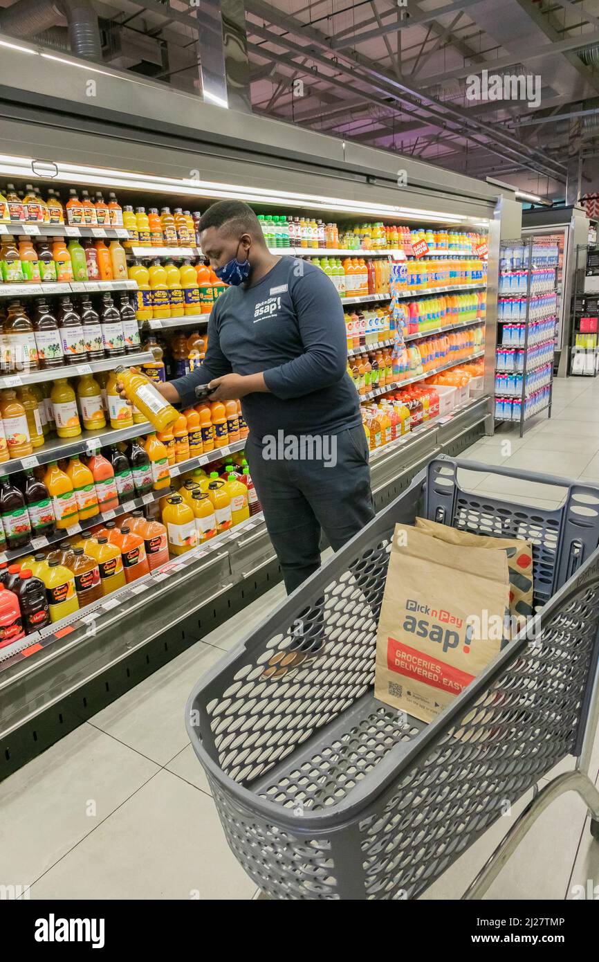 Cape Town, Afrique du Sud - 9 septembre 2021 : un membre du personnel cueille des produits à partir de l'étagère pour un service de livraison express à domicile Banque D'Images