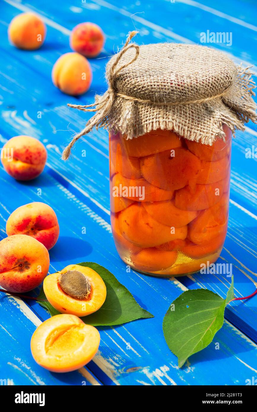 Compote d'abricot maison dans un pot en verre et fruits abricot sur une  table en bois bleu. Fruits conservés et abricot mûr en saison de récolte  Photo Stock - Alamy