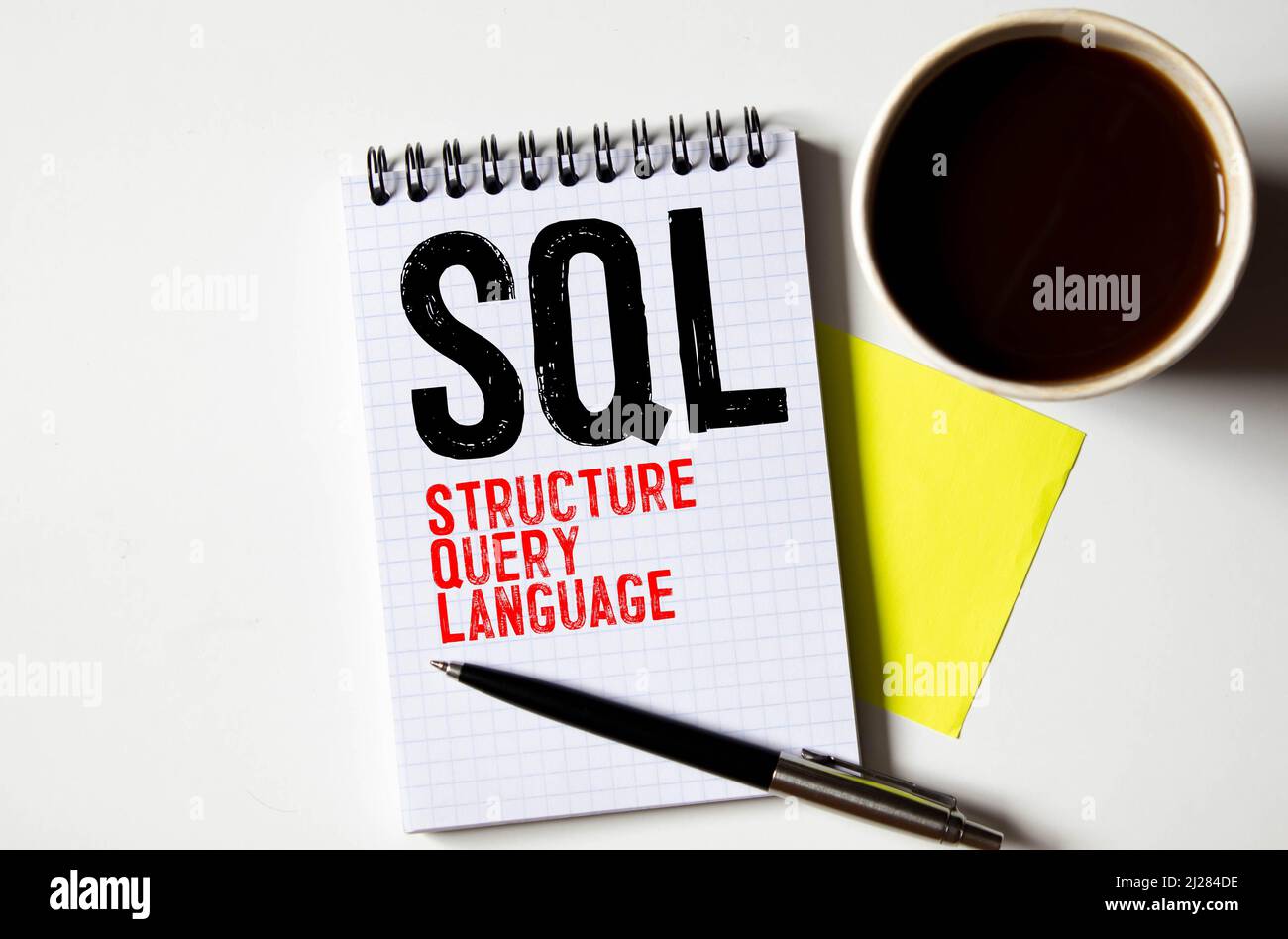 Vue de dessus du clavier, de la corbeille, du presse-papiers, du stylo et du papier écrit avec SQL. Banque D'Images