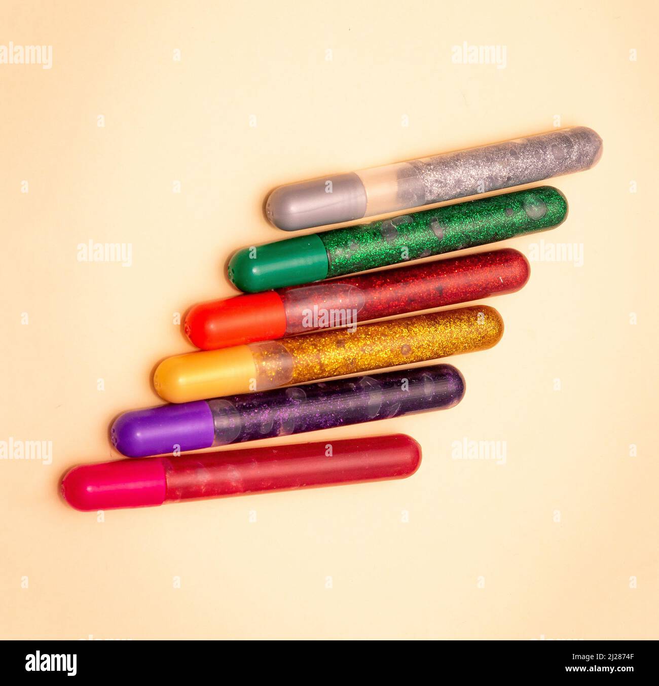 Crayons en gel coloré stylos scintillants isolés sur fond jaune Banque D'Images