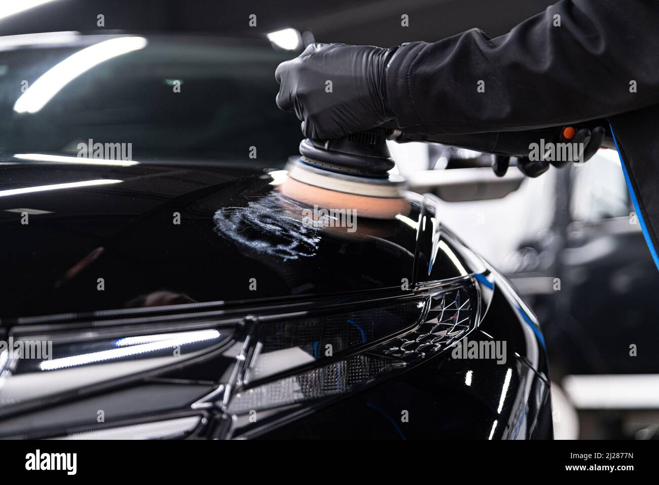 Homme ouvrier de voiture détaillant studio enlever les rayures sur le vernis de voiture Banque D'Images