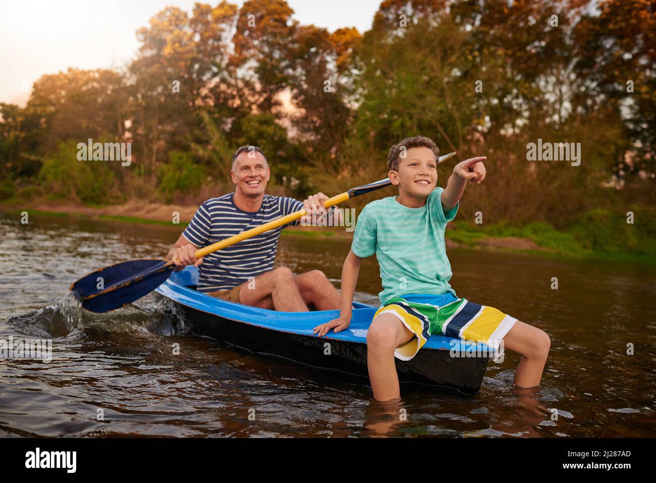 Profitez d'une promenade lente sur la rivière. Photo d'un père et d'un fils rasant un bateau ensemble sur un lac. Banque D'Images